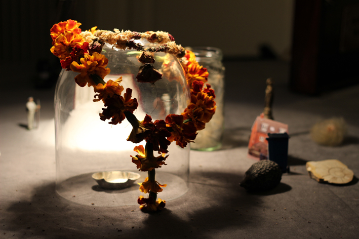 Marigold flower garland hangs over a glass dome with a salt cellar inside